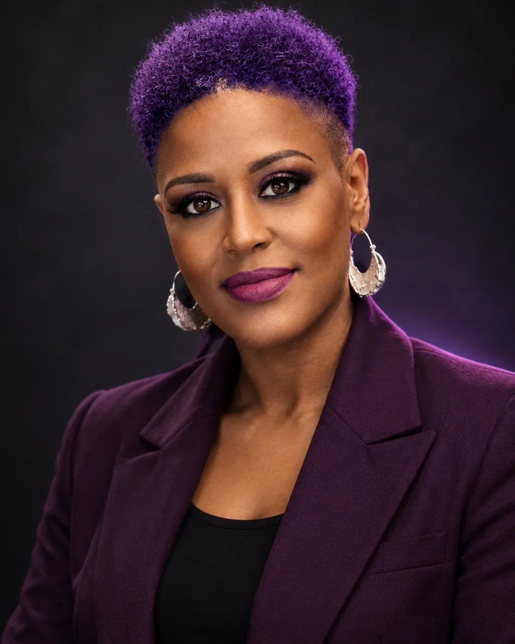Tia Jakes standing confidently in a plum suit